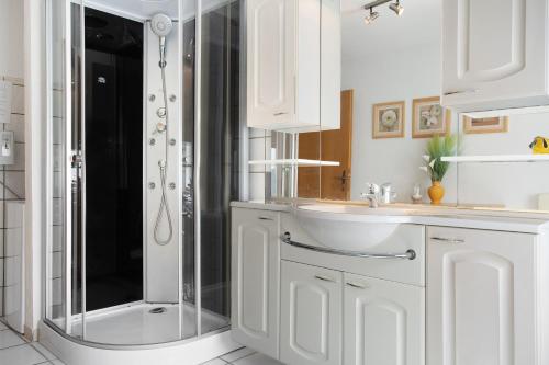 a white bathroom with a shower and a sink at Ferienwohnung Lüssow 