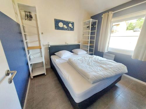 ein Schlafzimmer mit einem Bett, einem Fenster und Regalen in der Unterkunft 2 bedrooms chalet with wifi at Somme Leuze in Somme-Leuze