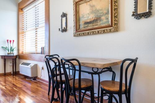 a dining room table with chairs and a picture on the wall at Colonial 1 - studio apartment overlooking the Black River in South Haven