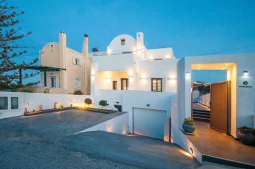 a large white house with a garage at night at Elvis’ Home in Fira