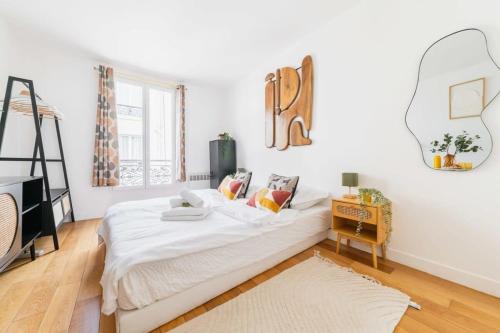 une chambre blanche avec un lit et une table dans l'établissement Studio fonctionnel et confortable - Paris 10 - 2P - FLAT-GUEST, à Paris