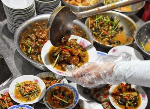 a person is serving food in bowls of food at Homestay Phủ Cam in Thôn Trường Giang