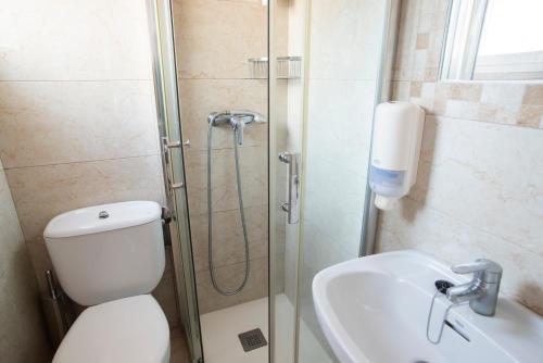 a bathroom with a shower and a toilet and a sink at Hostal Mar y Huerta in Es Cana