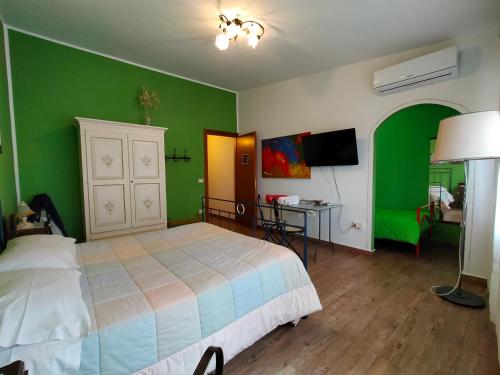 Schlafzimmer mit grünen Wänden, einem Bett und einem Schreibtisch in der Unterkunft Casa Vacanze TwentyMiles in Castellana Sicula