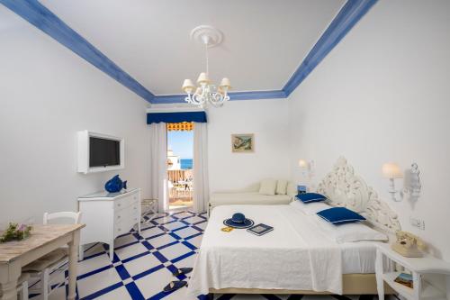 a bedroom with a bed and a desk and a television at Villa Flavio Gioia in Positano