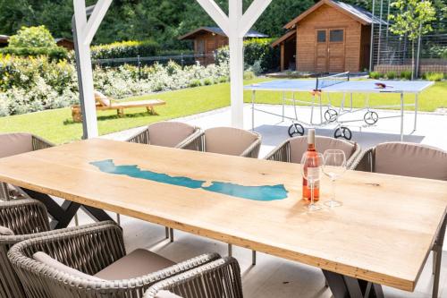 a wooden table with a bottle and glasses on it at Otthon Földváron in Balatonföldvár
