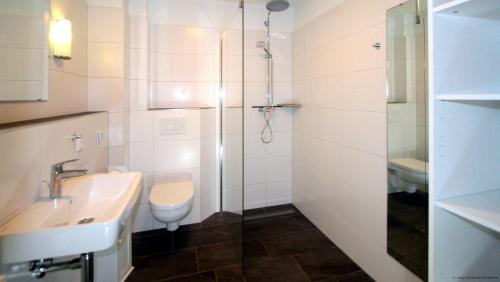 a bathroom with a shower and a toilet and a sink at 3-Zimmer-Fewo-mit-Sauna-Ferienwohnung-MM5 in Süderhöft