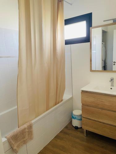 a bathroom with a shower curtain and a sink at Villa Egurra, à proximité d'une plage de sable fin in Santec