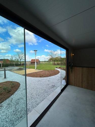 a room with a large glass door with a view of a driveway at Vakantiehuis Laurine in Deinze