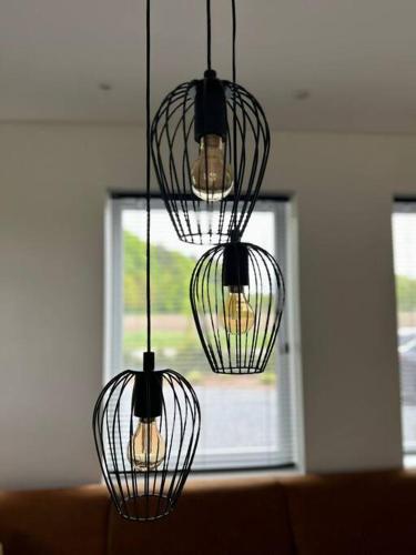 four lights hanging from a ceiling with a window at Vakantiehuis Laurine in Deinze