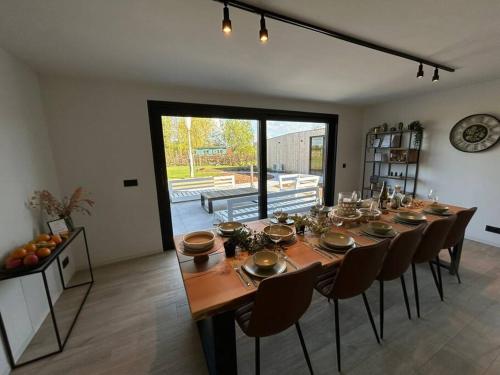 a dining room with a long table and chairs at Vakantiehuis Laurine in Deinze