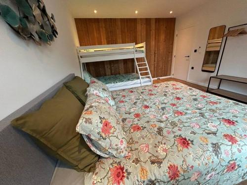 a bedroom with a large bed with a floral blanket at Vakantiehuis Laurine in Deinze