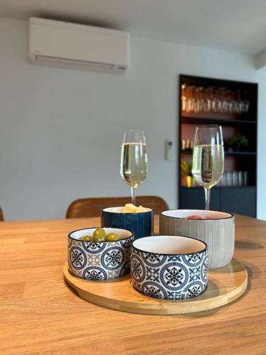 a table with two glasses of wine and bowls on it at Vakantiehuis Laurine in Deinze