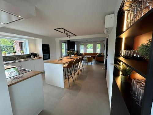 a kitchen and living room with a table and chairs at Vakantiehuis Laurine in Deinze