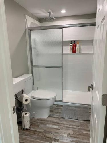 a bathroom with a toilet and a glass shower at ENTIRE 2 BEDROOM APARTMENT DOWNTOWN - u5 in Waterloo