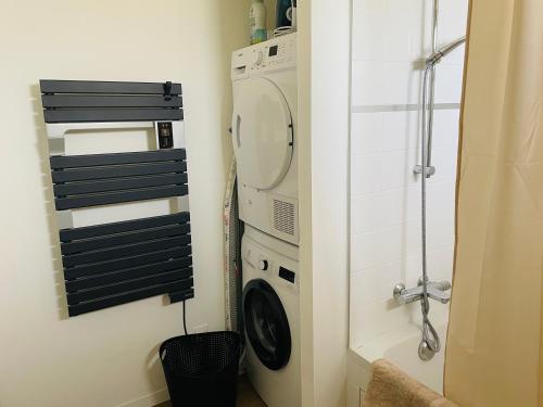 a bathroom with a washing machine and a washer at Villa Egurra, à proximité d'une plage de sable fin in Santec