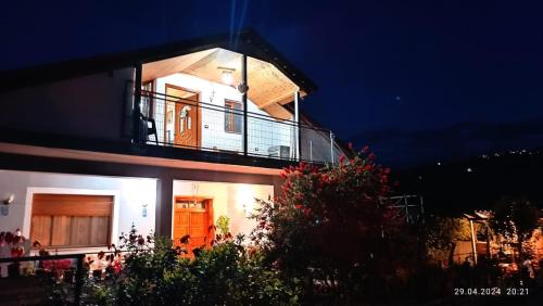 a house with a balcony on the side of it at night at Samuela Cozy Retreat in Berat