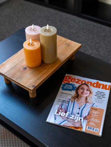a table with two candles and a magazine at Verblijf bij Bynt in Sneek