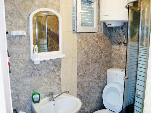 W łazience znajduje się toaleta, umywalka i lustro. w obiekcie 3 bedrooms chalet with enclosed garden and wifi at Herceg Novi 2 km away from the slopes w mieście Herceg Novi