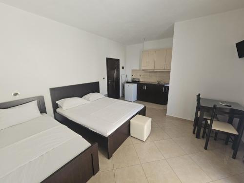 um quarto com 2 camas, uma mesa e uma cozinha em Vila Maison em Ksamil