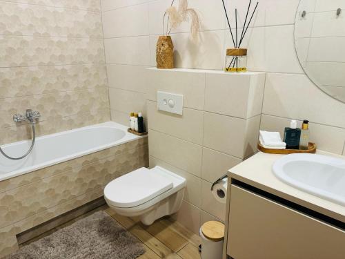 een witte badkamer met een toilet en een wastafel bij Moon apartment in Druskininkai