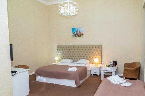 a bedroom with a large bed and a chandelier at Sahil Ark Hotel Baku in Baku