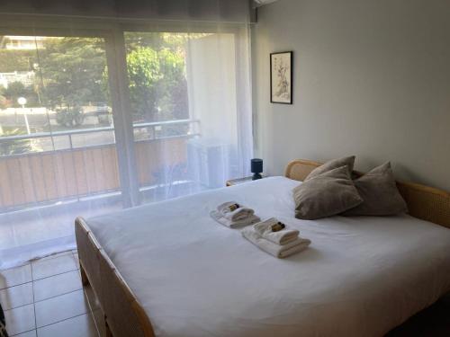 une chambre avec un grand lit avec des serviettes dessus dans l'établissement Le Trident YourHostHelper, à Cannes