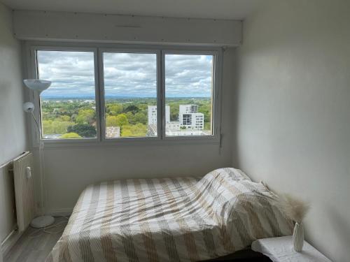 1 dormitorio con cama y ventana grande en Chambres d'Hôtes Kennedy, Villejean, en Rennes