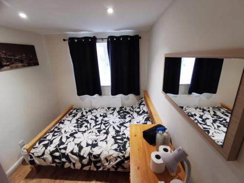 um pequeno quarto com uma cama e um espelho em Private room in a lovely home em Bicester