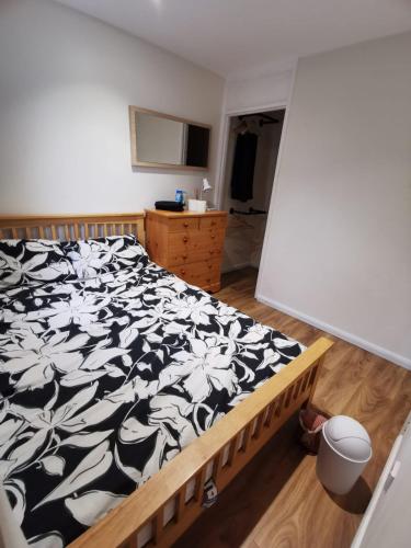um quarto com uma cama com um cobertor preto e branco em Private room in a lovely home em Bicester