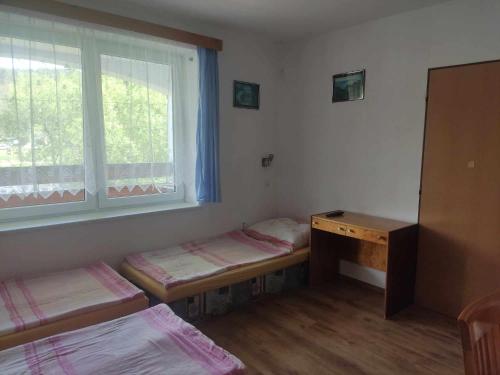 Zimmer mit 2 Betten, einem Schreibtisch und einem Fenster in der Unterkunft Ubytování Pod hradem Dobronice 111 in Dobronice
