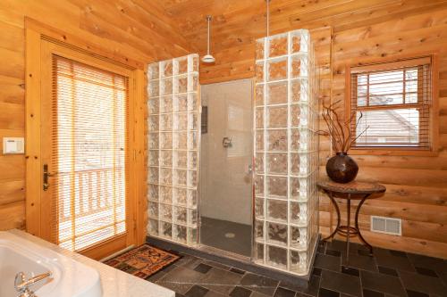 a bathroom with a shower and a bath tub at Swan Lodge - Walking distance to downtown Saugatuck - Modern Cabin Getaway! in Saugatuck