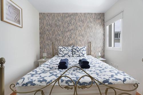 a bedroom with a bed with blue and white sheets at Nido Andrea in San Isidro