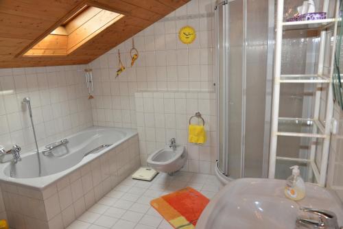 een badkamer met een bad, een wastafel en een toilet bij Ferienwohnungen Haus Monika in Aschau im Chiemgau