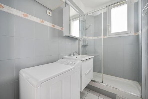 une salle de bain blanche avec un lavabo et une douche dans l'établissement L'Imprévu - 6pers - Wifi - Paris - Disney, à Vitry-sur-Seine