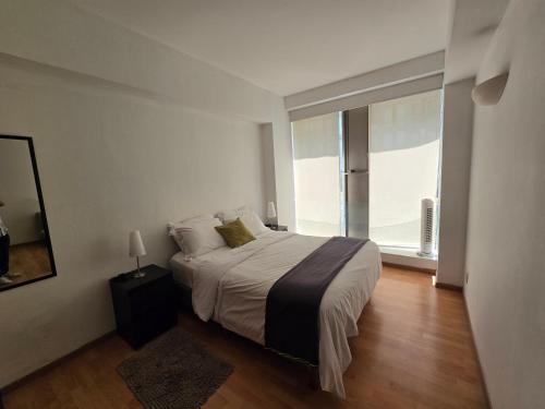 a bedroom with a large bed and a large window at Amazing Location Behind Hilton Hotel in Mexico City