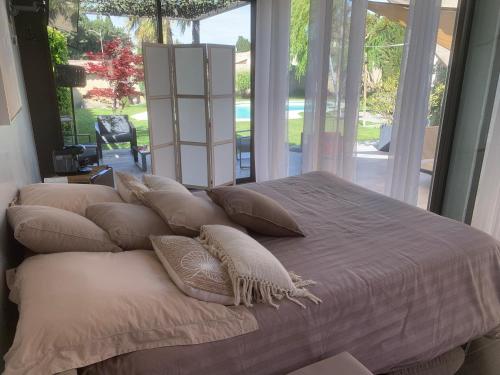 - un grand lit avec des oreillers dans la chambre dans l'établissement Guest House Ginoux, à Rognonas