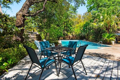 a patio with a table and chairs next to a pool at Jack's Place-Gulf Brz-Pool-Close to Bchs 2BD-1BT in Gulf Breeze