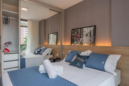 a bedroom with two beds and a mirror at JSmart#304 - Apartamento em Fortaleza by Carpediem in Fortaleza