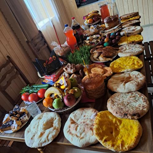 a table topped with lots of different types of bread at Chvibiani Guesthouse & Bar in Ushguli