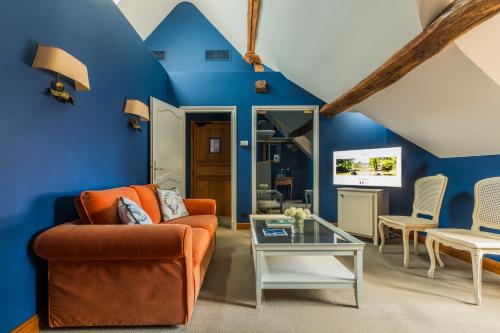 a living room with blue walls and an orange couch at Les Hauts de Loire Relais & Châteaux in Onzain
