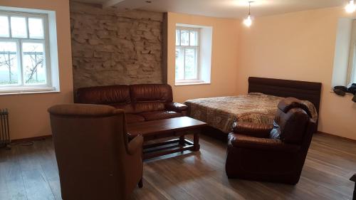um quarto com uma cama, um sofá e cadeiras em Nidra em Aizkraukle