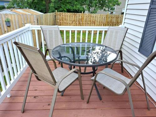 three chairs and a glass table on a deck at School Street Haven - 4 bedroom 2 bath sleeps 10 and is centrally located to downtown South Haven in South Haven