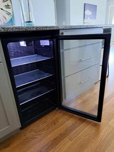 a black refrigerator with a glass door in a room at School Street Haven - 4 bedroom 2 bath sleeps 10 and is centrally located to downtown South Haven in South Haven