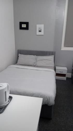 1 Schlafzimmer mit 2 Betten und einem Tisch mit Bettröcken in der Unterkunft Green Lodge-Room-06 in Liverpool