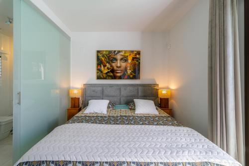 Schlafzimmer mit einem Bett mit Wandgemälde in der Unterkunft Luxe villa met verwarmd zwembad in Orihuela
