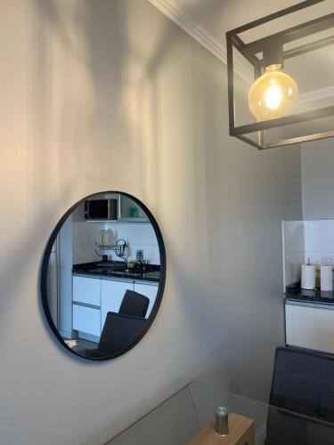 a mirror on a wall with a chair and a kitchen at Departamento Rivadavia in Santa Fe