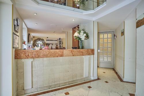 a lobby with a counter with a vase of flowers at Hotel Beaugrenelle Tour Eiffel in Paris