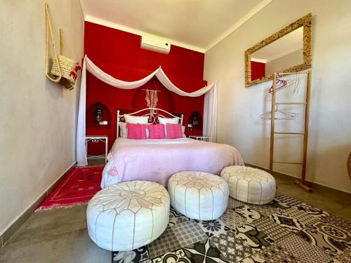 a bedroom with a bed with two ottomans at Jenny Lynn in Marrakech