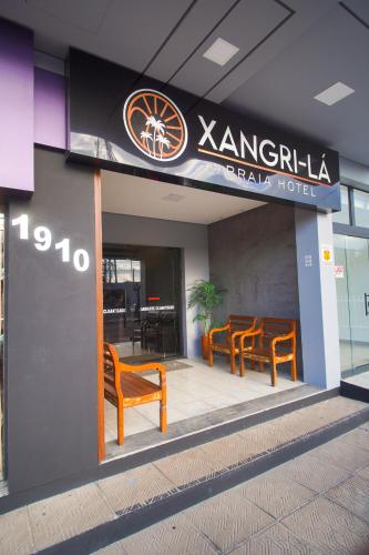 a group of chairs sitting outside of a hotel at Xangri-La Praia Hotel in Xangri-lá